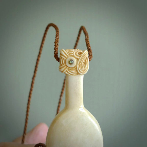 Hand carved engraved bone patu necklace hand made here in New Zealand. One only artistic patu pendant with hand plaited dark brown adjustable cord. Shipped to you with  Express Courier. Stand out patu pendant for men and women. Bone patu with Paua shell insert eyes.