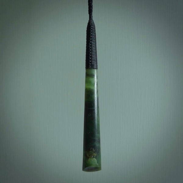 This photo shows a large jade drop shaped pendant. It a a lovely two-one green jade. Majority of this piece is a dark green colour with a semi-translucent top of the drop. The cord is black and is adjustable in length. Hand carved by Darren Hill.