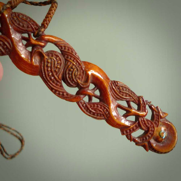 This necklace is carved from cow bone and stained with a homemade tea dye. It is a unique piece of wearable art that is sure to catch the eye. The shape is a complex twist form and has been beautifully hand carved by bone carver Yuri Terenyi.