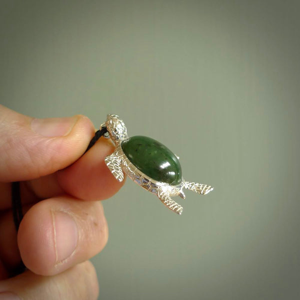 New Zealand Jade stone turtle in Sterling silver engraved casing. Hand carved jewellery made by NZ Pacific and for sale online. Moana, Ocean, jewellery hand carved in fire agate and Sterling Silver turtle necklace.