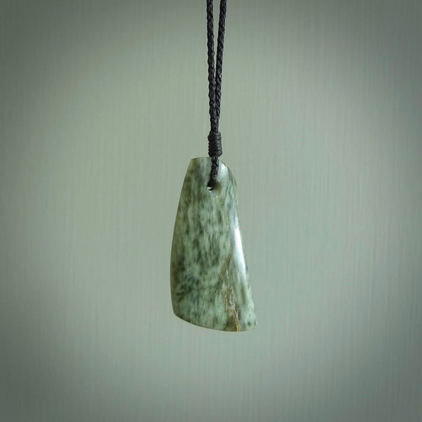 A hand carved curved contemporary drop pendant. This is a piece of genuine jade jewellery, hand carved by Raegan Bregmen. He has used rare New Zealand jade and has utilised his experience and carving skill to highlight the natural beauty of the stone. Delivered worldwide, postage is included in the price.