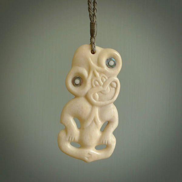 Hand carved bone Tiki pendant. Traditional art hand carved for NZ Pacific by Yuri Terenyi. Bone Tiki necklace with Paua Shell eyes.
