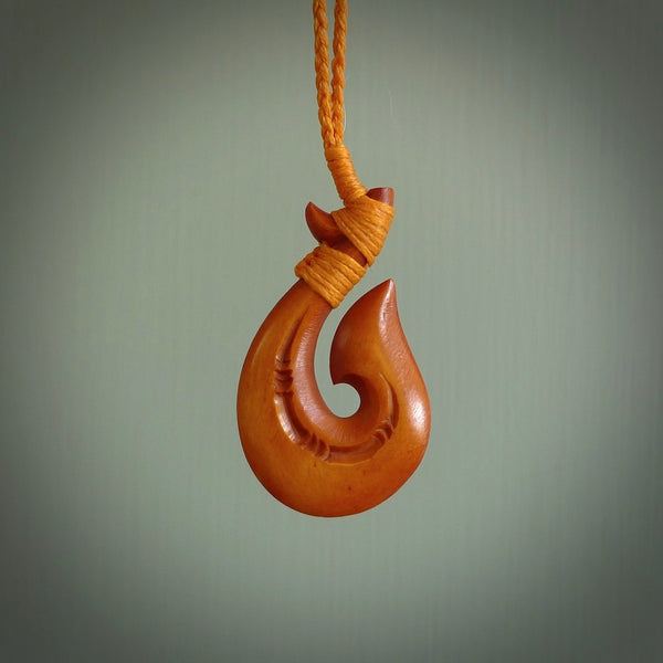 Medium sized, hand carved engraved bone hook, matau. Made in New Zealand by Yuri Terenyi for NZ Pacific. Hand made natural bone hook necklace for men and women. Stained bone hook necklace.