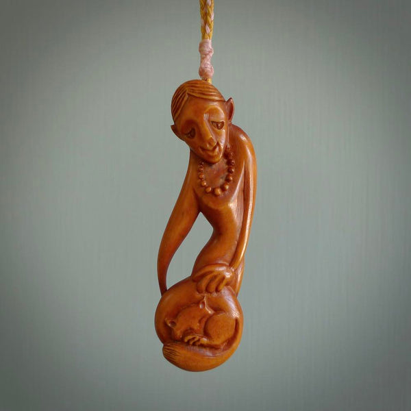 Hand carved stained bone female pendant in a repose shape with her cat. Made from natural bone. Bone jewellery from the Pacific for sale online. Female pendant for men and women.