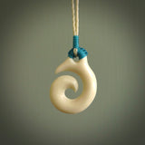 Natural cow bone hook with koru pendant. Hand carved by Yuri Terenyi in New Zealand. Maori design pendant for sale online. One only natural bone hook with koru necklace. Free delivery worldwide.