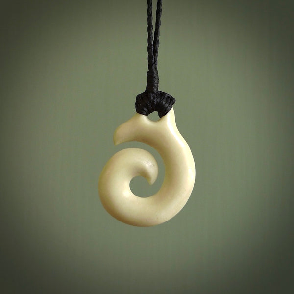 Natural cow bone hook with koru pendant. Hand carved by Yuri Terenyi in New Zealand. Maori design pendant for sale online. One only natural bone hook with koru necklace. Free delivery worldwide.