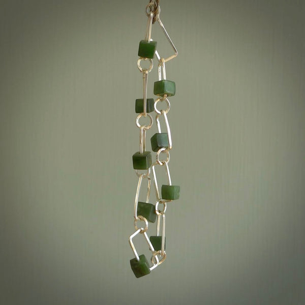 This bracelet is handmade from New Zealand Jade and sterling silver. It has a delicate cube of pounamu within each link of Sterling Silver chain and the Jade moves within each chain link.