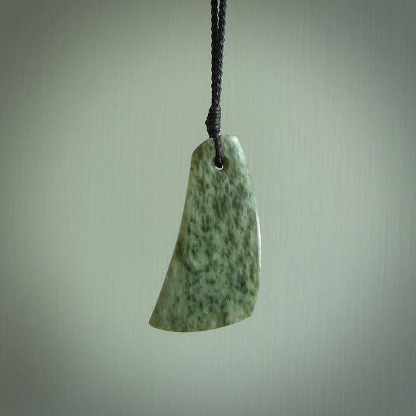 A hand carved curved contemporary drop pendant. This is a piece of genuine jade jewellery, hand carved by Raegan Bregmen. He has used rare New Zealand jade and has utilised his experience and carving skill to highlight the natural beauty of the stone. Delivered worldwide, postage is included in the price.