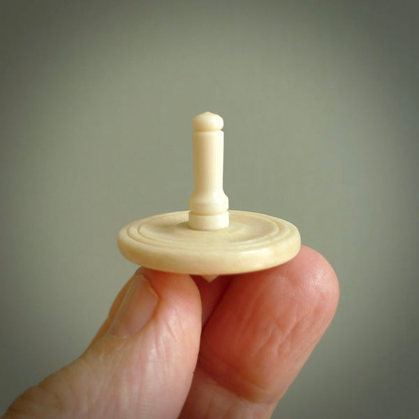 A traditional hand carved bone spinning top toy. This piece is made from bone and is a fully functioning toy that can be played with. Beautiful, contemporary art hand made by NZ Pacific.