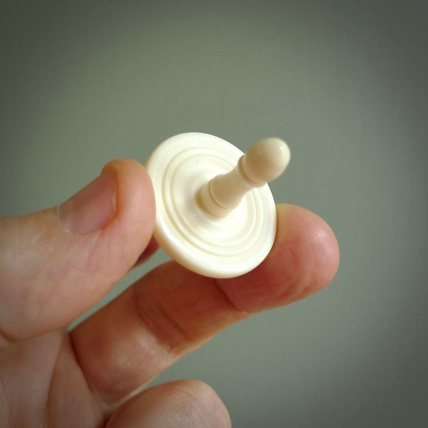 A traditional hand carved bone spinning top toy. This piece is made from bone and is a fully functioning toy that can be played with. Beautiful, contemporary art hand made by NZ Pacific.