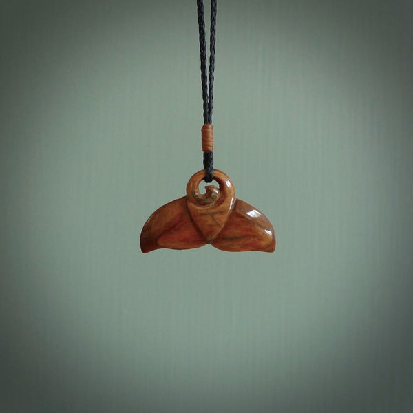This photo shows a small whaletail pendant that we have carved from a dark honey coloured piece of Woolly Mammoth tusk. It is suspended on a Black cord that is length adjustable.