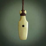 Hand carved engraved bone toki necklace hand made here in New Zealand. One only artistic toki pendant with hand plaited dark brown adjustable cord. Shipped to you with DHL Express Courier. Stand out toki pendant for men and women. Bone Toki with engraved NZ Pacific logo on the back and buffalo horn  insert on the front.