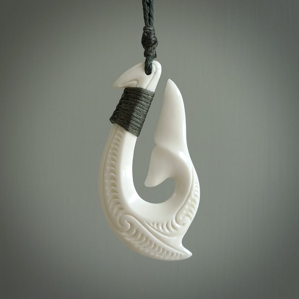 A handcarved hook pendant with a whaletail end. This is carved from bone and is detailed with a traditional Maori engraved design. We will ship this piece to you anywhere in the world and the price for shipping is included in the price. Unique bone jewellery for sale online at www.nzpacific.com