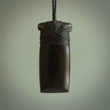 This photo shows wooden toki pendants. The cord is length adjustable which allows the pendant to be positioned where it suits you best. The toki was carved for us in hard wood. Unique art to wear.