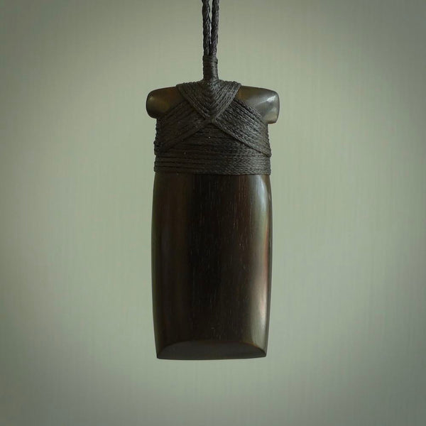 This photo shows wooden toki pendants. The cord is length adjustable which allows the pendant to be positioned where it suits you best. The toki was carved for us in hard wood. Unique art to wear.