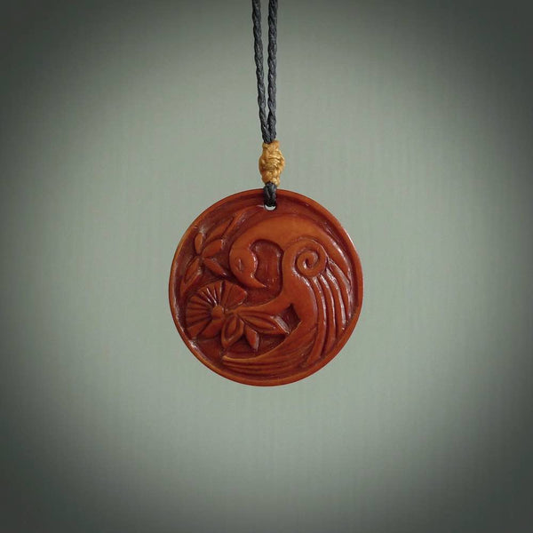 Hand carved natural stained bone contemporary disc pendant with creative and unique carvings on the front face of each individual piece.