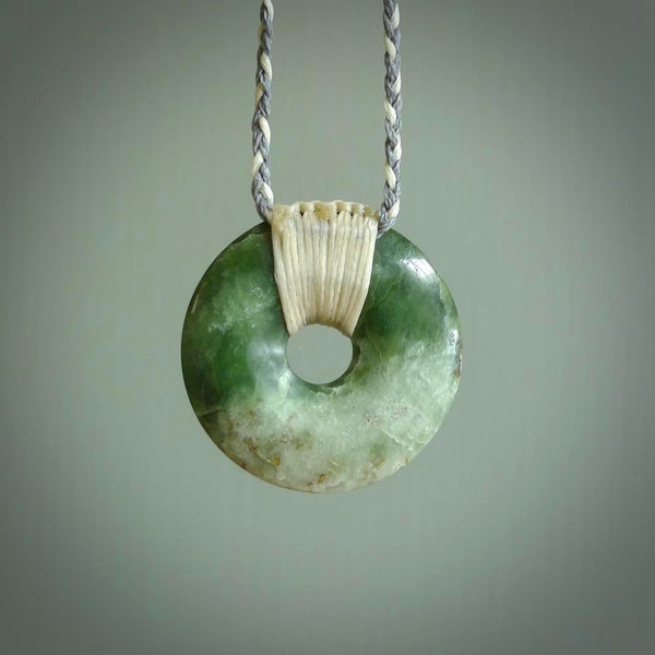 These are medium sized pendants - very finely carved. They are New Zealand Jade discs with a centre hole. It is suspended from a cord which is adjustable. These are beautiful pieces of expressive jade jewellery. Unique New Zealand made pendants for men and women. Perfect gifts for all.
