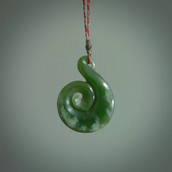 This pendant is a large sized and beautiful koru necklace carved from an orange and green piece of New Zealand Flower Jade. Ross Crump carved this piece for us so the workmanship is outstanding. Handmade in New Zealand, a beautiful piece of jade jewellery.