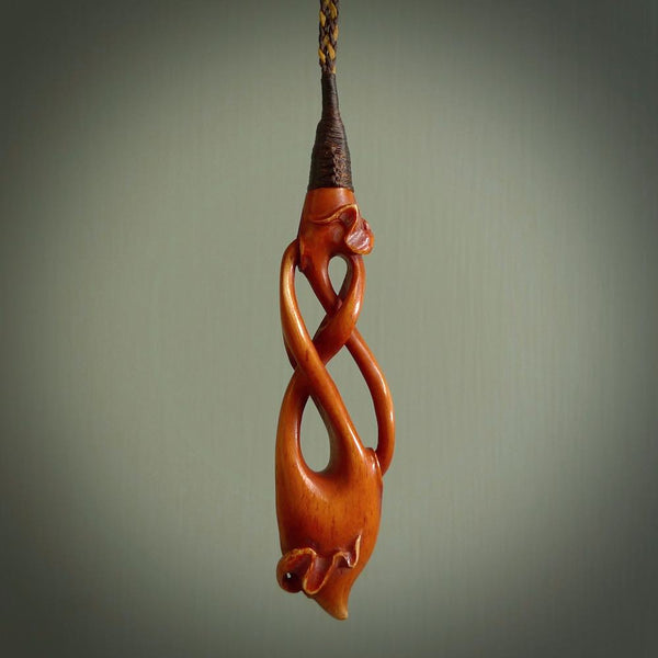 This necklace is carved from cow bone and stained with a homemade tea dye. It is a unique piece of wearable art that is sure to catch the eye. The shape is a complex twist form and has been beautifully hand carved by bone carver Yuri Terenyi.