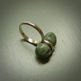 This is a handcrafted New Zealand Marsden jade squeezed ring with sterling silver. This is a solid little work of art. We ship this worldwide for free and are happy to answer any questions that you may have about these or other products on our website.