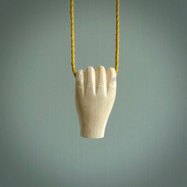 Hand carved pendant symbolising strength and hope - Shown worn. Carved by NZ Pacific from ancient woolly mammoth tusk. Unique jewellery for sale online.