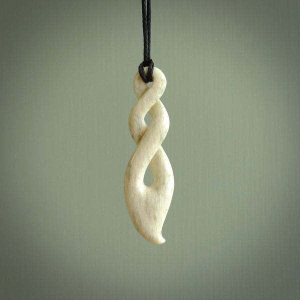 A hand carved twist design pendant from Whale Bone. The cord is black and adjustable in length. Large hand made twist necklace by New Zealand artist Kerry Thompson.