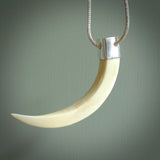 Hand carved, engraved Boars Tusk Pendant with a sterling silver cap. Hand made pendant carved from a boars tusk. Hand made unique jewellery for sale by NZ Pacific online.