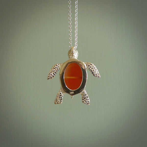 Fire Agate stone turtle in Sterling silver engraved casing. Hand carved jewellery made by NZ Pacific and for sale online. Moana, Ocean, jewellery hand carved in fire agate and Sterling Silver turtle necklace.