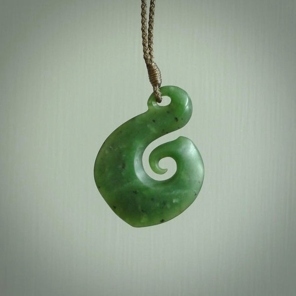 This matau, with koru, is carved from a very striking New Zealand jade. It is both intricate and simple in design - it has hidden folds and smooth curves. A piece to be worn or displayed - the carving and the jade are both magnificent.