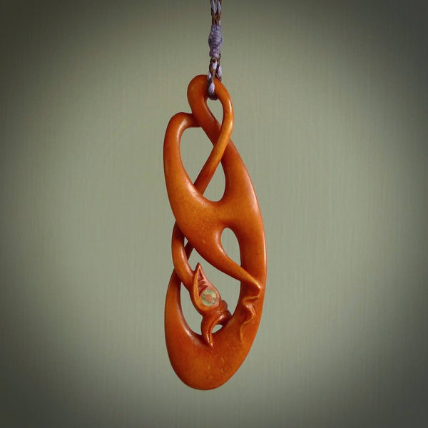 This necklace is carved from cow bone and stained with a homemade tea dye. It is a unique piece of wearable art that is sure to catch the eye. The shape is a complex twist form and has been beautifully hand carved by bone carver Yuri Terenyi.