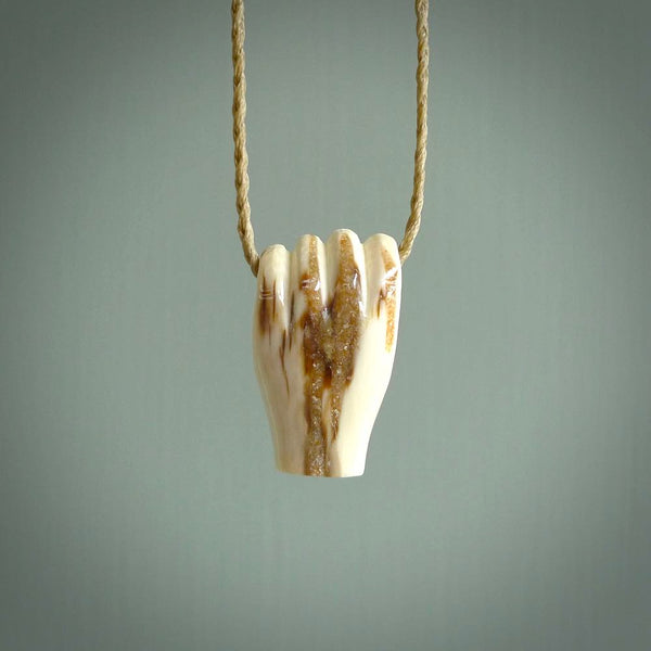 Hand carved pendant symbolising strength and hope - Shown worn. Carved by NZ Pacific from ancient woolly mammoth tusk. Unique jewellery for sale online.