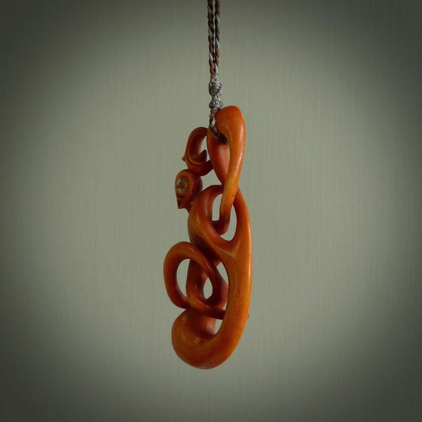 This necklace is carved from cow bone and stained with a homemade tea dye. It is a unique piece of wearable art that is sure to catch the eye. The shape is a complex twist form and has been beautifully hand carved by bone carver Yuri Terenyi.