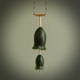 This is a very dark green flower bud pendant carved here in New Zealand by Josey Coyle. It is handmade carved jade double flower buds one placed above the other on a fine silver wire. The top is a T-shaped tube through which a silver necklace chain passes. The jade florets are handcarved from beautiful dark green New Zealand Marsden Jade and the chain is handmade from sterling silver wire.