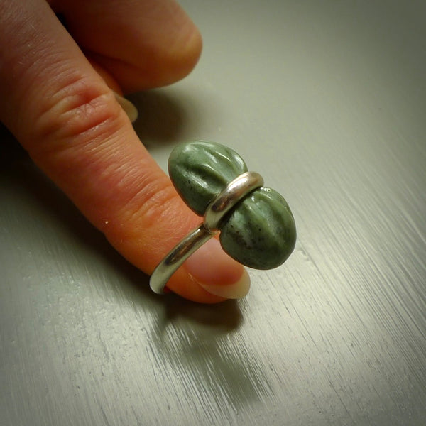 This is a handcrafted New Zealand Marsden jade squeezed ring with sterling silver. This is a solid little work of art. We ship this worldwide for free and are happy to answer any questions that you may have about these or other products on our website.