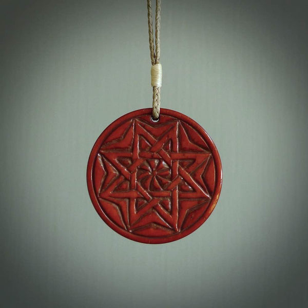 Hand carved natural stained bone contemporary disc pendant with creative and unique carvings on the front face of each individual piece.