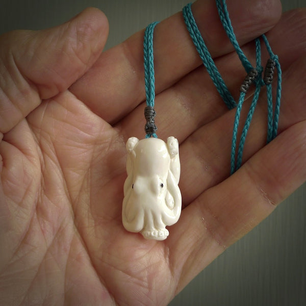This is a beautiful little hand carved octopus pendant. It is a very cute little pendant that we have carved in natural, untreated bone. We provide these in two cord colours, Black, Pale Honey and Paradise Blue and we shipping is included worldwide so there are no hidden costs when you reach checkout. Hand carved jewellery by NZ Pacific for sale online.