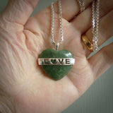 Hand crafted New Zealand jade love heart necklace. This piece has  a sterling silver love written across its' body. This necklace is provided with a sterling silver chain.