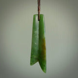 This piece is a fine, delicate pendant. It was carved for us by Ric Moor from a lovely semi-translucent green piece of New Zealand Marsden jade. It is suspended on an dark brown  four plaited braided cord that is length adjustable.