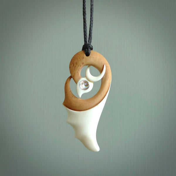 A hand carved bone contemporary bird pendant. The cord is a black colour and is a fixed length. A medium sized hand made contemporary necklace by New Zealand artist Kerry Thompson. Kerry has stained parts of the bone which really add to the dimension of this pendant. One off work of art to wear.