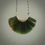 This is a very dark green fan design pendant that we has been carved here in New Zealand by Josey Coyle. It is carved from a piece of New Zealand Marsden flower Jade pounamu with Sterling Silver fittings and a sterling silver chain. A contemporary fan shaped pendant made to wear.