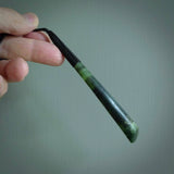 This photo shows a large jade drop shaped pendant. It a a lovely two-one green jade. Majority of this piece is a dark green colour with a semi-translucent top of the drop. The cord is black and is adjustable in length. Hand carved by Darren Hill.