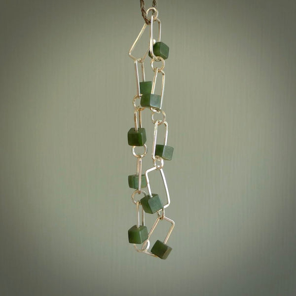 This bracelet is handmade from New Zealand Jade and sterling silver. It has a delicate cube of pounamu within each link of Sterling Silver chain and the Jade moves within each chain link.