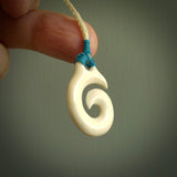 Natural cow bone hook with koru pendant. Hand carved by Yuri Terenyi in New Zealand. Maori design pendant for sale online. One only natural bone hook with koru necklace. Free delivery worldwide.