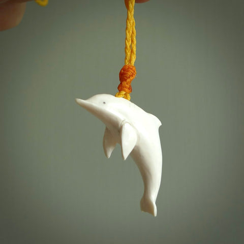Hand made Bone dolphin pendant carved for men and women. Hand carved Bone dolphin with adjustable cord. Gifts for lovers of dolphins and art to wear. Free delivery worldwide.