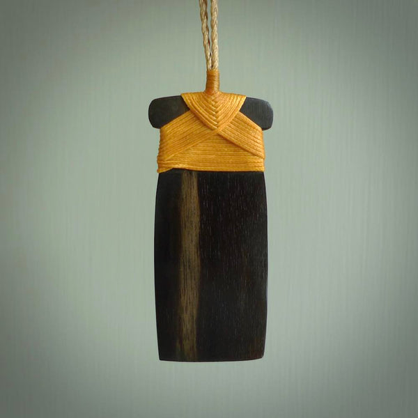 This photo shows wooden toki pendants. The cord is length adjustable which allows the pendant to be positioned where it suits you best. The toki was carved for us in hard wood. Unique art to wear.
