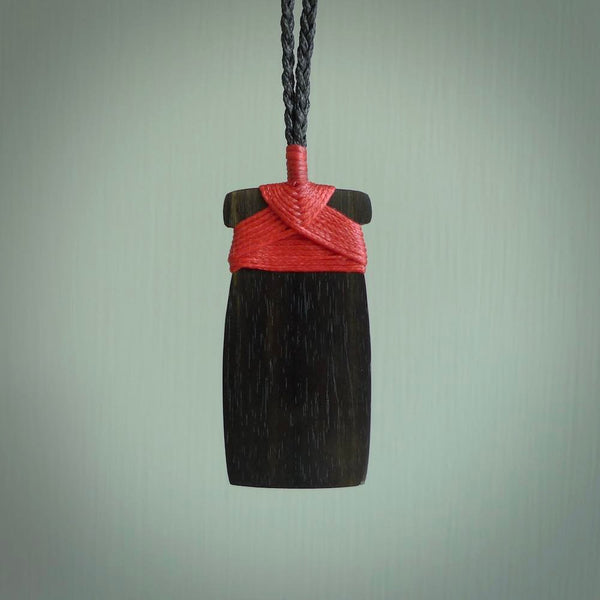 This photo shows wooden toki pendants. The cord is length adjustable which allows the pendant to be positioned where it suits you best. The toki was carved for us in hard wood. Unique art to wear.