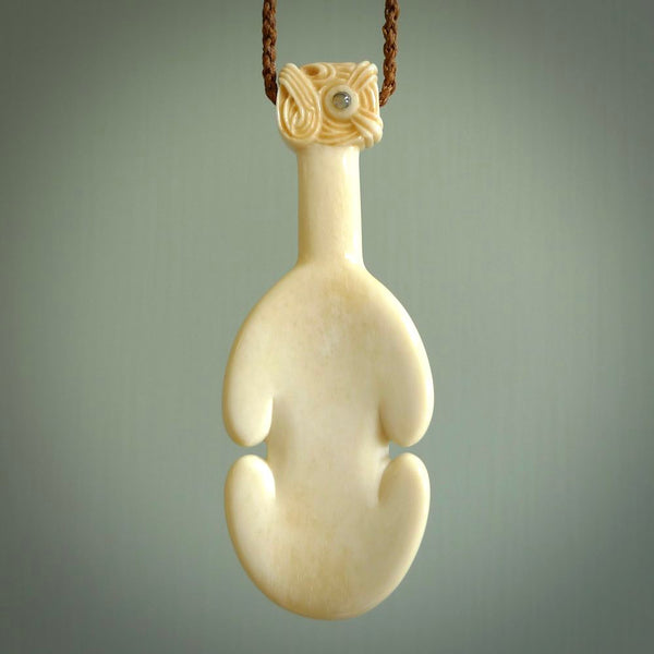 Hand carved engraved bone patu necklace hand made here in New Zealand. One only artistic patu pendant with hand plaited dark brown adjustable cord. Shipped to you with  Express Courier. Stand out patu pendant for men and women. Bone patu with Paua shell insert eyes.