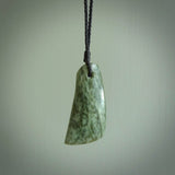 A hand carved curved contemporary drop pendant. This is a piece of genuine jade jewellery, hand carved by Raegan Bregmen. He has used rare New Zealand jade and has utilised his experience and carving skill to highlight the natural beauty of the stone. Delivered worldwide, postage is included in the price.
