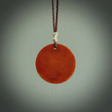 Hand carved natural stained bone contemporary disc pendant with creative and unique carvings on the front face of each individual piece.