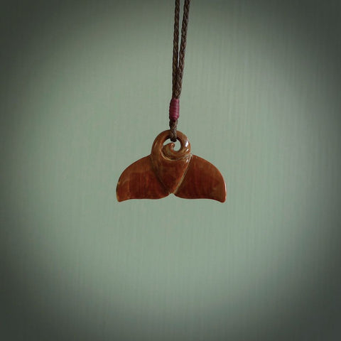 This photo shows a small whaletail pendant that we have carved from a dark honey coloured piece of Woolly Mammoth tusk. It is suspended on a Chocolate cord that is length adjustable.